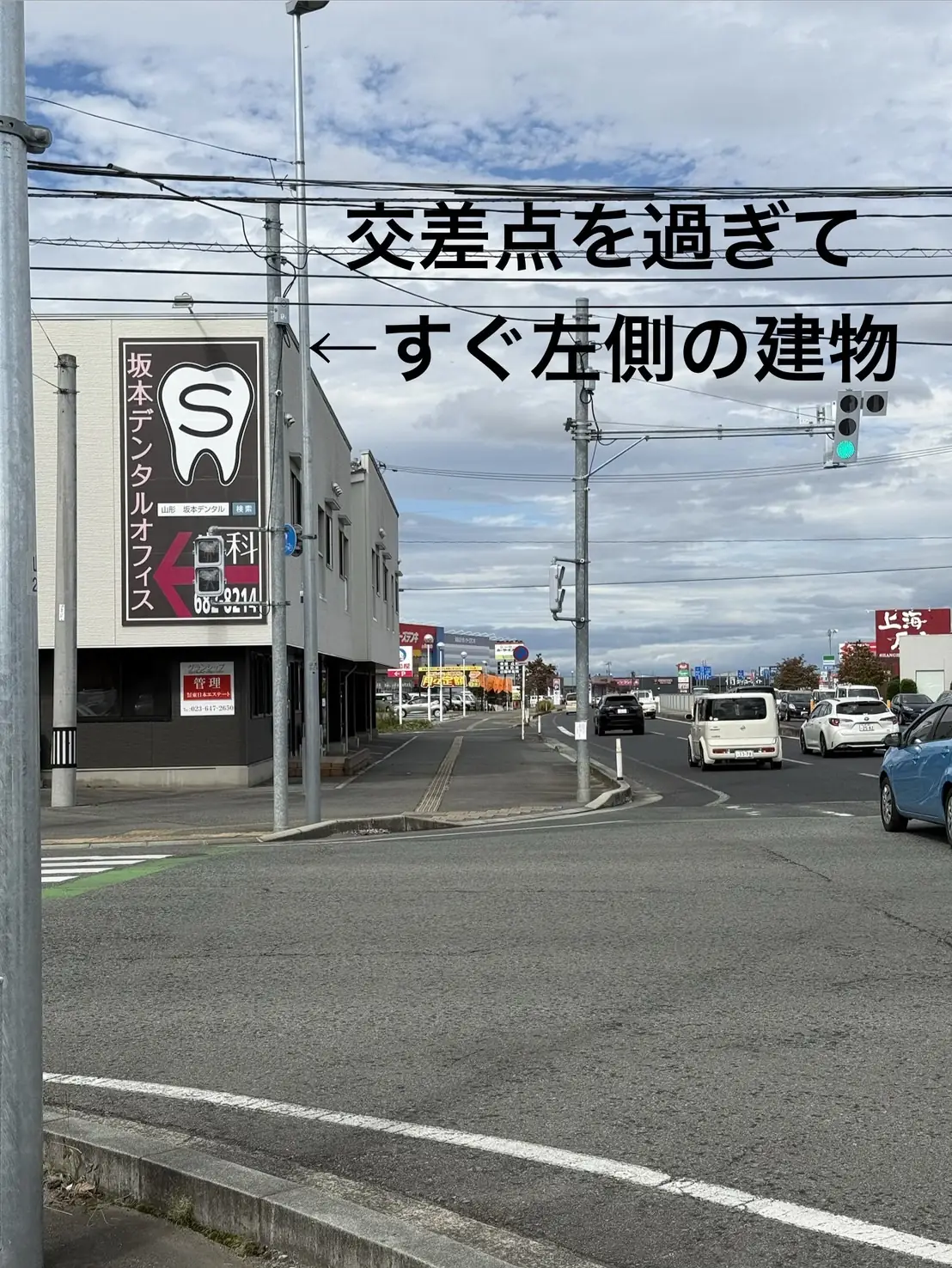 江俣交差点を過ぎてすぐ左側にある、坂本デンタルオフィスの看板がある建物。写真には「交差点を過ぎて ←すぐ左側の建物」と書かれている